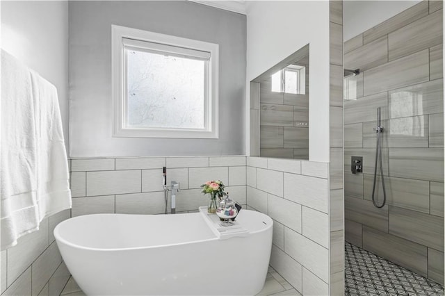2828 Mistletoe St, New Orleans, LA 70118 - bathroom with tile walls, a walk in shower, a freestanding tub, and a wainscoted wall