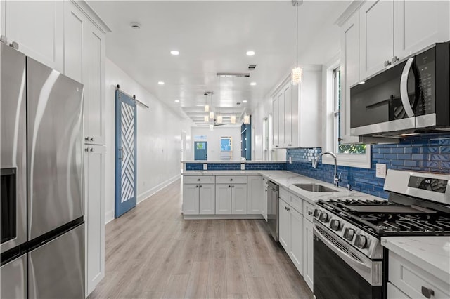 3414 Monroe St, New Orleans, LA 70118 - kitchen featuring appliances with stainless steel finishes, a sink, a peninsula, recessed lighting, and light stone counters