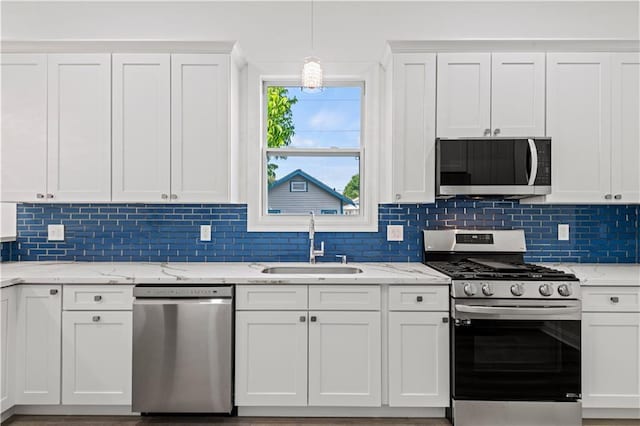 3414 Monroe St, New Orleans, LA 70118 - kitchen with appliances with stainless steel finishes, a sink, white cabinetry, tasteful backsplash, and light stone countertops