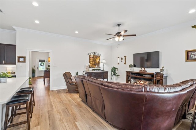 22039 Giselle Dr, Mandeville, LA 70471 - living room with a ceiling fan, light wood finished floors, ornamental molding, recessed lighting, and baseboards