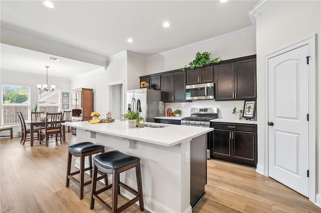 22039 Giselle Dr, Mandeville, LA 70471 - kitchen with stainless steel appliances, a kitchen breakfast bar, a chandelier, crown molding, and a kitchen island with sink