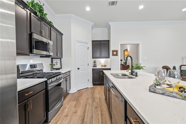 22039 Giselle Dr, Mandeville, LA 70471 - kitchen with stainless steel appliances, a sink, light wood finished floors, ornamental molding, and tasteful backsplash