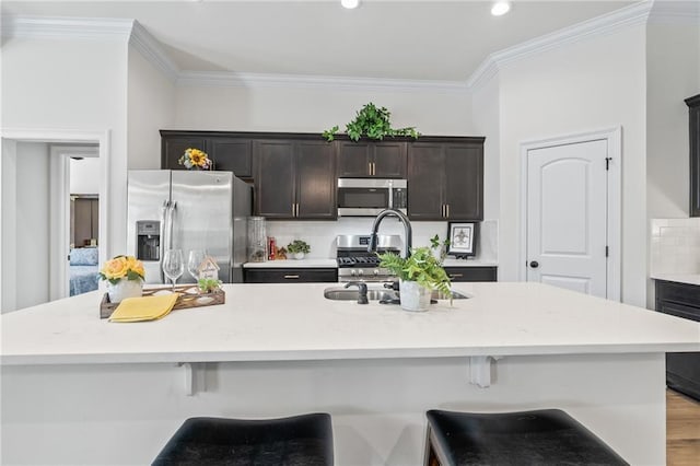 22039 Giselle Dr, Mandeville, LA 70471 - kitchen featuring stainless steel appliances, a sink, backsplash, crown molding, and a breakfast bar