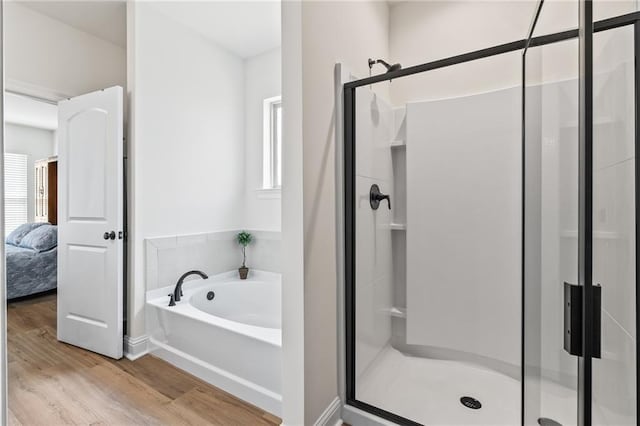 22039 Giselle Dr, Mandeville, LA 70471 - ensuite bathroom with healthy amount of natural light, a garden tub, a stall shower, and wood finished floors