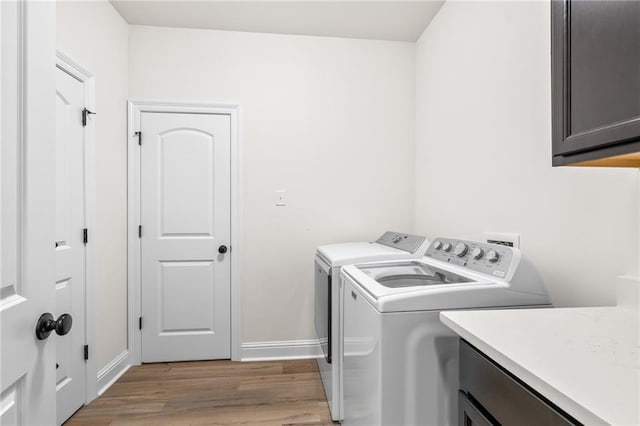 22039 Giselle Dr, Mandeville, LA 70471 - laundry room featuring cabinet space, washer and clothes dryer, baseboards, and light wood-style flooring