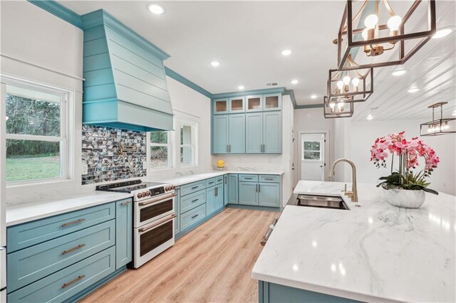 21507 Birtrue Rd, Bush, LA 70431 - kitchen featuring a sink, double oven range, a chandelier, wall chimney range hood, and light wood-style flooring