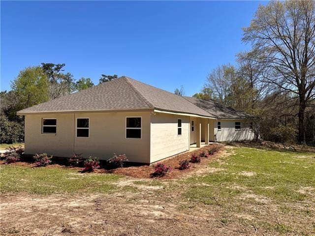 21507 Birtrue Rd, Bush, LA 70431 - view of side of property featuring a yard, a shingled roof, and stucco siding