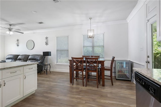 1951 Beth Dr, Slidell, LA 70458 - dining area with beverage cooler, plenty of natural light, ornamental molding, light wood-style floors, and a ceiling fan