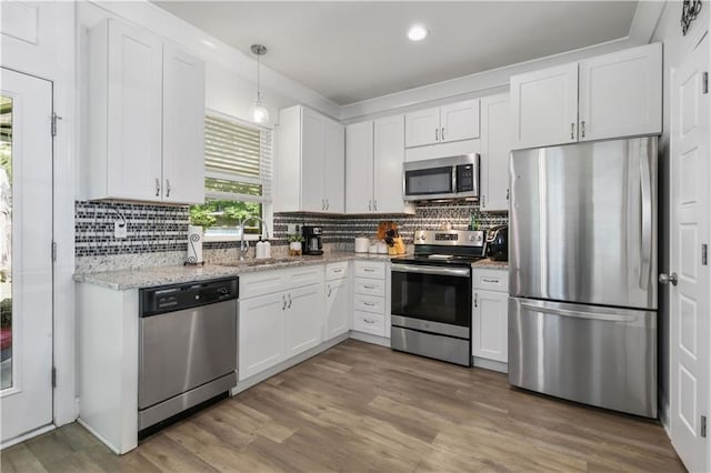 1951 Beth Dr, Slidell, LA 70458 - kitchen with stainless steel appliances, a sink, white cabinets, decorative backsplash, and recessed lighting