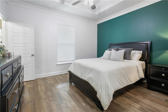 1951 Beth Dr, Slidell, LA 70458 - bedroom featuring wood finished floors, baseboards, crown molding, a tray ceiling, and a ceiling fan