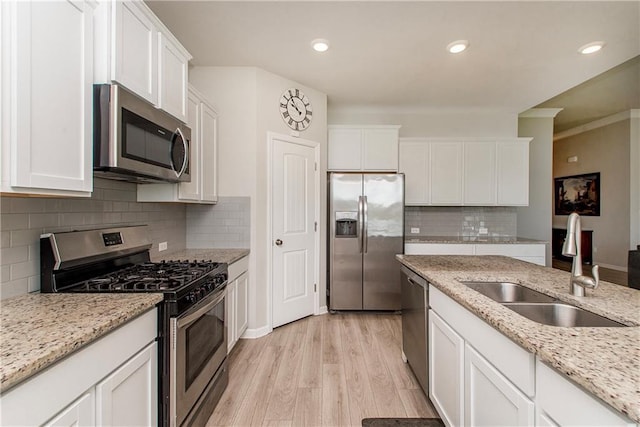 40262 Sedgwick Ln, Ponchatoula, LA 70454 - kitchen featuring stainless steel appliances, white cabinetry, light wood-style flooring, decorative backsplash, and recessed lighting