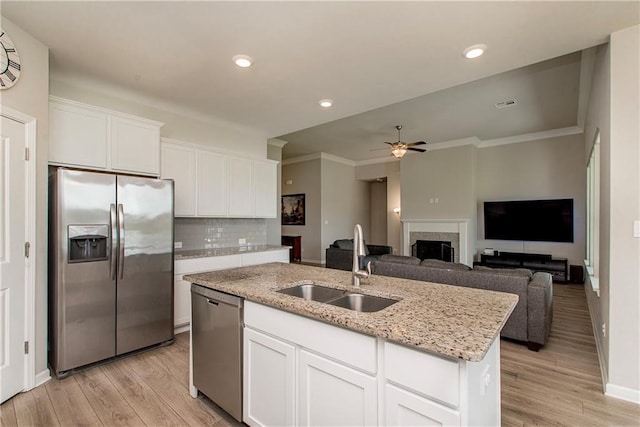 40262 Sedgwick Ln, Ponchatoula, LA 70454 - kitchen with appliances with stainless steel finishes, a kitchen island with sink, a ceiling fan, light stone counters, and white cabinetry