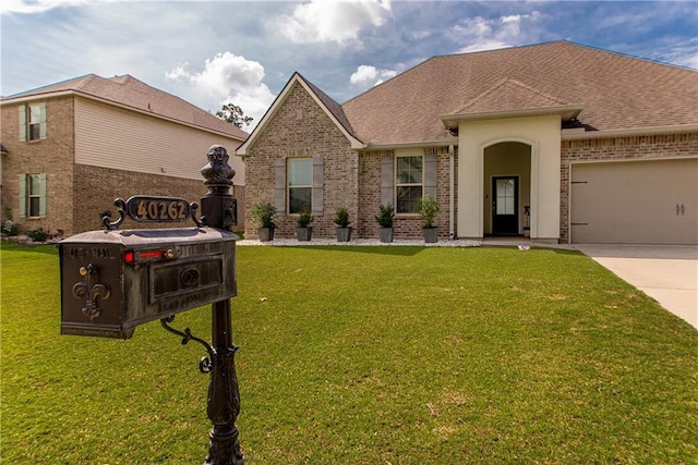 40262 Sedgwick Ln, Ponchatoula, LA 70454 - view of front of home featuring brick siding, an attached garage, and a front yard