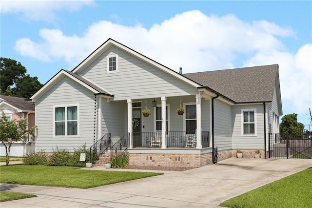 1908 Alexander Ave, Arabi, LA 70032 - view of front facade featuring a porch, driveway, and roof with shingles