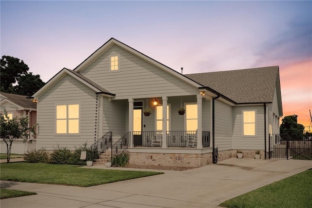 1908 Alexander Ave, Arabi, LA 70032 - view of front of property with covered porch, a yard, concrete driveway, and a shingled roof