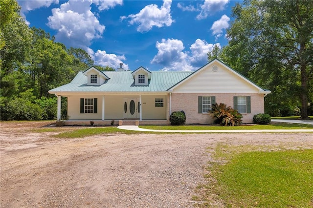 39311 Okefenokee Rd, Pearl River, LA 70452 - view of front of property with covered porch, a front lawn, metal roof, and brick siding