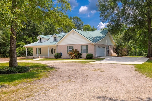 39311 Okefenokee Rd, Pearl River, LA 70452 - view of front facade with driveway, an attached garage, a porch, and metal roof