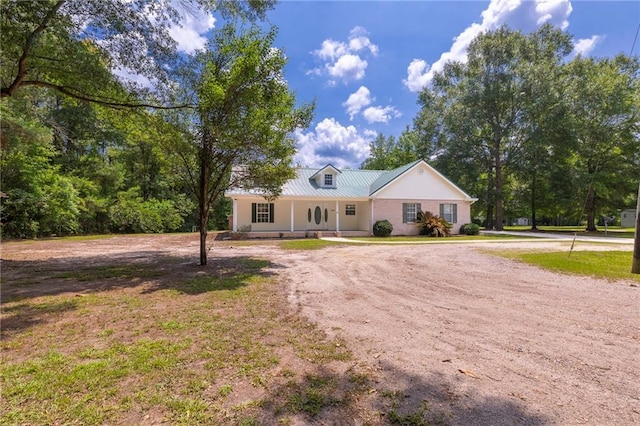 39311 Okefenokee Rd, Pearl River, LA 70452 - view of front of property featuring dirt driveway, metal roof, covered porch, and a front lawn