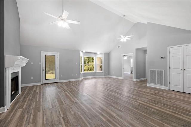 39311 Okefenokee Rd, Pearl River, LA 70452 - unfurnished living room featuring a ceiling fan, high vaulted ceiling, a fireplace, wood finished floors, and baseboards