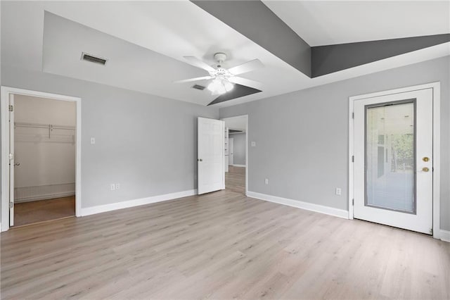 39311 Okefenokee Rd, Pearl River, LA 70452 - unfurnished bedroom featuring a walk in closet, baseboards, light wood finished floors, and a ceiling fan