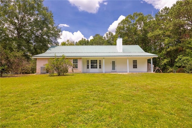 39311 Okefenokee Rd, Pearl River, LA 70452 - back of house with a yard, a chimney, covered porch, and metal roof