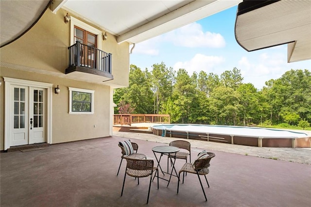 404 Warrior Trce, Covington, LA 70435 - view of patio with a balcony, an outdoor pool, french doors, and view of scattered trees