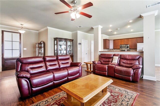 481 Scotch Pine Dr, Ponchatoula, LA 70454 - living room featuring ornate columns, a ceiling fan, dark wood-type flooring, crown molding, and baseboards
