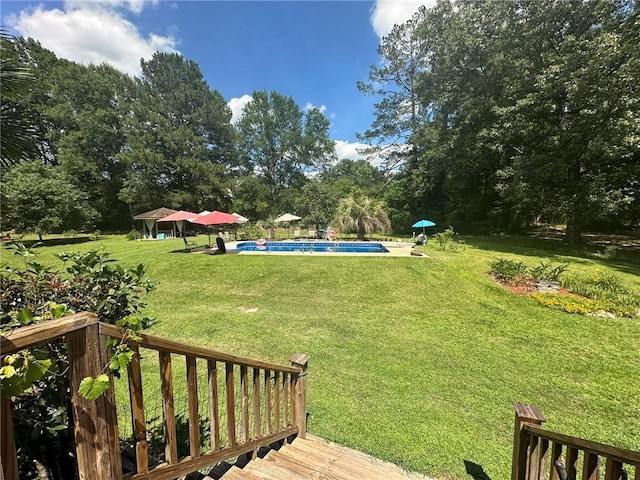 30010 River Rd, Mount Hermon, LA 70450 - view of grassy yard featuring a wooden deck, an outdoor pool, and view of wooded area