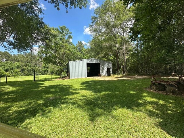 30010 River Rd, Mount Hermon, LA 70450 - view of grassy yard with a pole building, a detached garage, and an outdoor structure