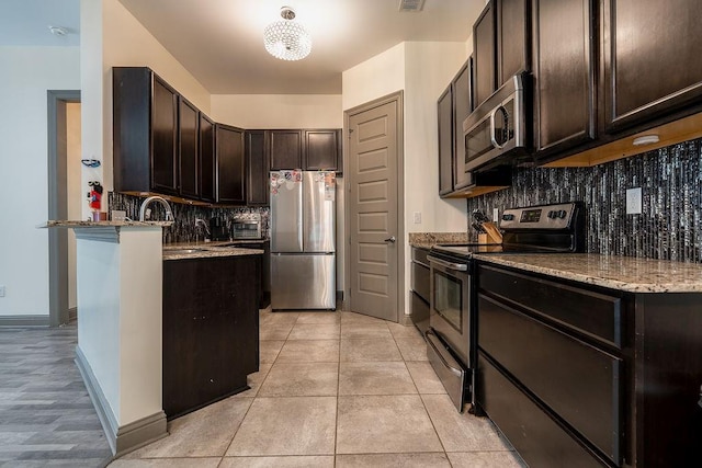136 Oak Leaf Dr, Slidell, LA 70461 - kitchen featuring stainless steel appliances, a sink, tasteful backsplash, and dark brown cabinets