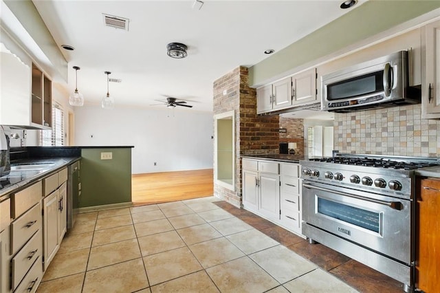 5936 Dover Pl, New Orleans, LA 70131 - kitchen with appliances with stainless steel finishes, light tile patterned floors, decorative backsplash, dark countertops, and a ceiling fan