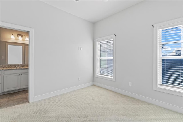 344 Ormond Dr, Covington, LA 70433 - unfurnished bedroom with light colored carpet, connected bathroom, baseboards, and a sink