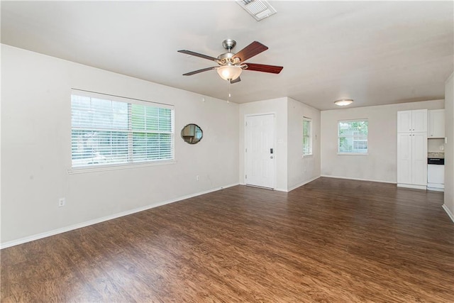 1029 W 32nd Ave, Covington, LA 70433 - unfurnished living room featuring dark wood-style floors, ceiling fan, and baseboards