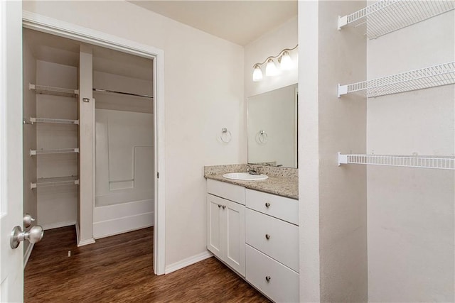 1029 W 32nd Ave, Covington, LA 70433 - bathroom featuring vanity, wood finished floors, and baseboards