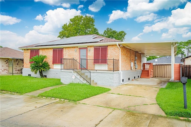 131 Ann St, Saint Rose, LA 70087 - view of front of property featuring brick siding, roof mounted solar panels, concrete driveway, and an attached carport