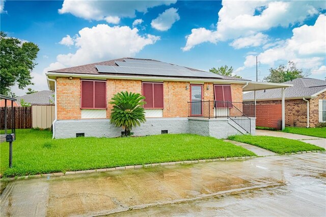131 Ann St, Saint Rose, LA 70087 - view of front of home with roof mounted solar panels, brick siding, concrete driveway, a carport, and crawl space