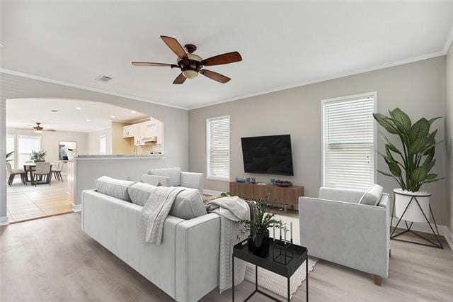 15 E Chalmette Cir, Chalmette, LA 70043 - living room with a ceiling fan, ornamental molding, light wood-style floors, baseboards, and arched walkways