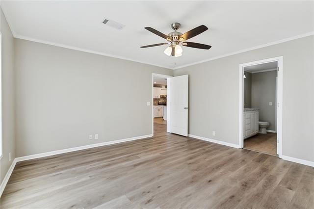 15 E Chalmette Cir, Chalmette, LA 70043 - unfurnished bedroom featuring crown molding, wood finished floors, baseboards, and ensuite bath