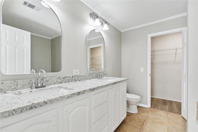 15 E Chalmette Cir, Chalmette, LA 70043 - full bath featuring crown molding, double vanity, toilet, tile patterned flooring, and a walk in closet