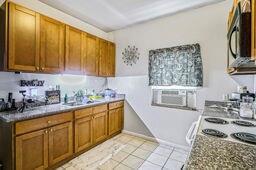 291618 Andover St, Jefferson, LA 70121 - kitchen with brown cabinetry, cooling unit, and light tile patterned floors