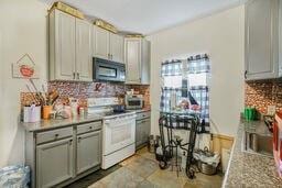 291618 Andover St, Jefferson, LA 70121 - kitchen featuring black microwave, white electric range oven, decorative backsplash, gray cabinets, and light countertops