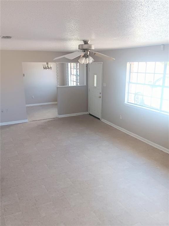 1938 Longwood Ct, La Place, LA 70068 - empty room with a ceiling fan, a textured ceiling, baseboards, and a chandelier