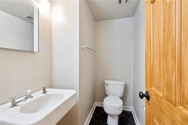 1020 Esplanade Ave Unit 204, New Orleans, LA 70116 - bathroom featuring toilet, tile patterned flooring, a sink, and baseboards