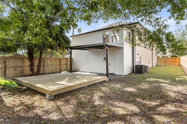 2526 Metairie Rd, Metairie, LA 70001 - back of property with a fenced backyard, stucco siding, a wooden deck, and central AC unit