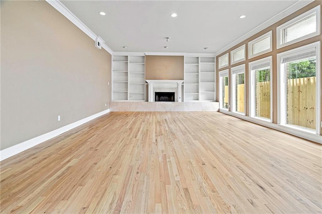 1 Miller Ln, Metairie, LA 70002 - unfurnished living room featuring baseboards, ornamental molding, built in features, light wood-type flooring, and a premium fireplace