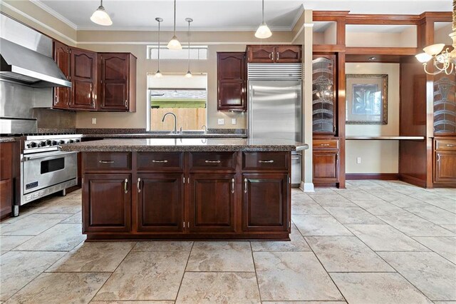 1 Miller Ln, Metairie, LA 70002 - kitchen featuring high quality appliances, wall chimney range hood, pendant lighting, crown molding, and dark stone countertops
