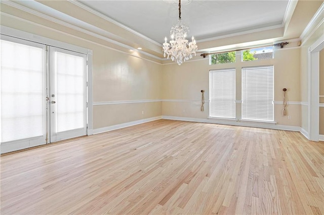 1 Miller Ln, Metairie, LA 70002 - spare room featuring a chandelier, light wood-type flooring, crown molding, a raised ceiling, and baseboards