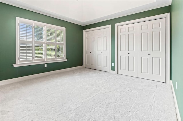 1 Miller Ln, Metairie, LA 70002 - unfurnished bedroom featuring two closets, carpet flooring, baseboards, and ornamental molding