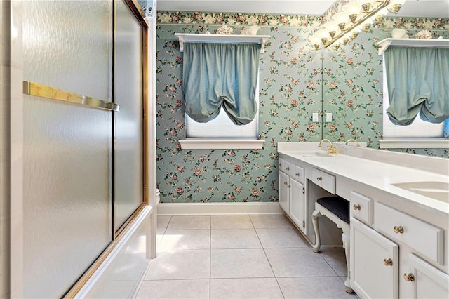 1 Miller Ln, Metairie, LA 70002 - bathroom featuring baseboards, wallpapered walls, tile patterned flooring, double vanity, and a shower with shower door