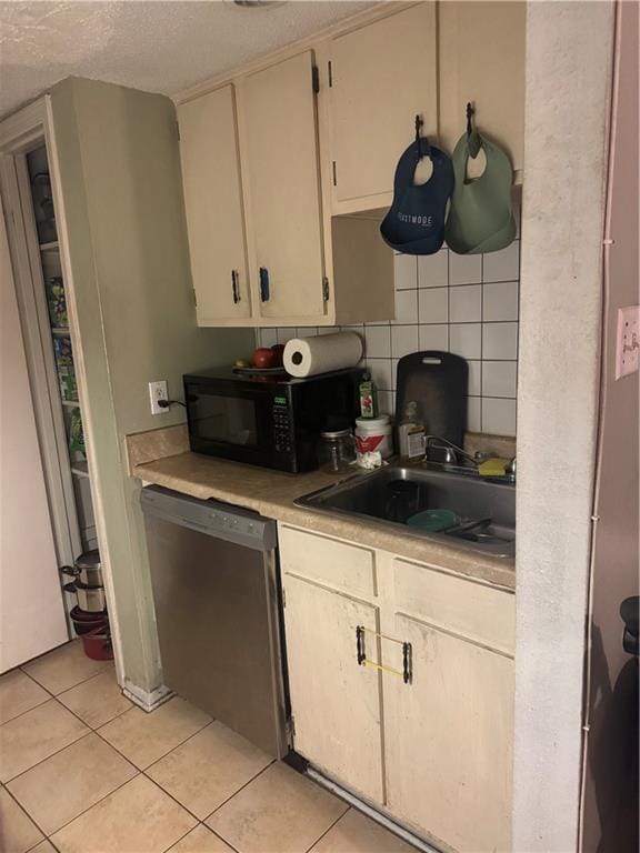 6220 Riverside Dr Unit 556, Metairie, LA 70003 - kitchen featuring stainless steel dishwasher, black microwave, light countertops, light tile patterned floors, and backsplash